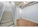 View of unfinished basement stairs leading to an open area with wood-look flooring and a door at 7505 Brookwood Way, Cumming, GA 30041