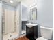 Modern bathroom with a stand-up shower, dark vanity, a modern sink, and a toilet at 7505 Brookwood Way, Cumming, GA 30041