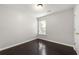 Cozy bedroom featuring hardwood floors, a window with blinds, baseboards, and a door at 7505 Brookwood Way, Cumming, GA 30041