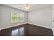 Bright bedroom with hardwood floors, a ceiling fan, and a window allowing natural light at 7505 Brookwood Way, Cumming, GA 30041