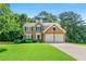 Beautiful two-story brick home with a well-manicured lawn and a two-car garage at 7505 Brookwood Way, Cumming, GA 30041