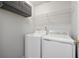 Bright laundry room features white appliances, overhead cabinets and shelving, offering plenty of storage space at 7505 Brookwood Way, Cumming, GA 30041