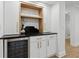 Stylish bar area with custom cabinets, black countertop, and wine refrigerator at 9165 Eves Cir, Roswell, GA 30076