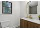 Cozy bathroom featuring a wood vanity, sink, and a framed mirror above at 9165 Eves Cir, Roswell, GA 30076