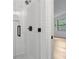 Walk-in shower featuring white subway tile, glass door, and matte black hardware at 9165 Eves Cir, Roswell, GA 30076