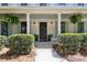 Inviting front porch with a stylish black door, hanging ferns, and manicured landscaping at 9165 Eves Cir, Roswell, GA 30076