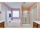 A bright bathroom with a soaking tub, glass-enclosed shower, and -and- vanities at 105 Lanier Xing, Hiram, GA 30141