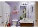 Bathroom in lavender tones with floral shower curtain, wood vanity, and framed mirror at 105 Lanier Xing, Hiram, GA 30141