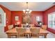 Elegant dining room featuring a large wooden table, chandelier, and red accent wall at 105 Lanier Xing, Hiram, GA 30141