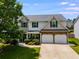 Two-story home with a two-car garage, landscaping, and combination brick and siding design at 105 Lanier Xing, Hiram, GA 30141