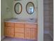 Bathroom vanity features double sinks, oval mirrors, wood cabinetry, and a linen closet at 172 Lakeview Dr, Newborn, GA 30056