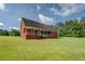 Rear view of brick house with a covered patio and spacious backyard at 172 Lakeview Dr, Newborn, GA 30056