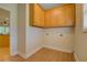 Bright laundry room featuring wood cabinets, wood flooring, and washer/dryer hookups at 172 Lakeview Dr, Newborn, GA 30056