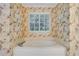 Bright bathroom featuring a corner tub beneath a window with floral wallpaper at 2935 Abbottswell Dr, Alpharetta, GA 30022