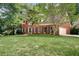 Traditional brick home with a well-kept lawn, featuring a two-car garage and mature trees at 2935 Abbottswell Dr, Alpharetta, GA 30022