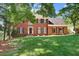 Beautiful brick home with black shutters and a green lawn, framed by mature trees at 2935 Abbottswell Dr, Alpharetta, GA 30022