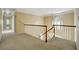 Upstairs hallway with a carpeted floor, wooden railing, and natural light at 2935 Abbottswell Dr, Alpharetta, GA 30022