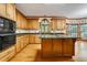 Spacious eat-in kitchen features wood cabinetry, a large island, and windows with views of the surrounding landscape at 2935 Abbottswell Dr, Alpharetta, GA 30022
