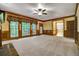 Spacious living room with wood trim, ceiling fan, and large windows overlooking the backyard at 2935 Abbottswell Dr, Alpharetta, GA 30022
