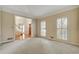Bright living room with carpeted floors and views to the foyer through an open doorway at 2935 Abbottswell Dr, Alpharetta, GA 30022