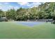 Tennis court featuring court lines and net, surrounded by trees at 2935 Abbottswell Dr, Alpharetta, GA 30022