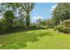 Large, grassy backyard with mature trees and shrubbery, providing ample space for outdoor activities at 3212 Georgian Woods Cir, Decatur, GA 30034