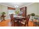 Dining room with hardwood floors, classic hutch and chandelier, set table, and natural light at 3212 Georgian Woods Cir, Decatur, GA 30034