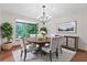 Elegant dining room with hardwood floors, round table, modern chandelier, sideboard, and window view at 3442 Winter Wood Trl, Marietta, GA 30062