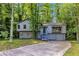 Charming gray two-story home with stone accents, a covered entryway, and a winding driveway surrounded by lush trees at 3442 Winter Wood Trl, Marietta, GA 30062