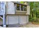 Attached two-car garage with a picture window and neutral exterior in a wooded setting at 3442 Winter Wood Trl, Marietta, GA 30062
