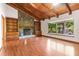Bright living room with hardwood floors, stone fireplace with wood mantel, built-in bookcases, and large picture window at 3442 Winter Wood Trl, Marietta, GA 30062