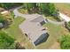 A beautiful aerial view of a secluded gray house with a long driveway, lush lawn, and mature trees at 411 Johnson Rd, Locust Grove, GA 30248