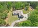 Aerial view of craftsman home with mature trees, landscaping, and a winding driveway at 411 Johnson Rd, Locust Grove, GA 30248