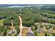 Aerial view of a sprawling property with a water tower in the distance, surrounded by lush greenery at 411 Johnson Rd, Locust Grove, GA 30248