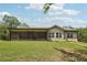 Wide shot of backyard featuring a screened-in porch, siding, and lush lawn at 411 Johnson Rd, Locust Grove, GA 30248