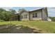 Spacious backyard showcasing the home's screened-in porch, siding, and lush greenery at 411 Johnson Rd, Locust Grove, GA 30248