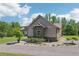 View of home featuring attached two-car garage, side yard, stone accents and well-manicured lawn at 411 Johnson Rd, Locust Grove, GA 30248