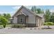 Side view of a home with gray siding, stone accents, two-car garage, and neat landscaping at 411 Johnson Rd, Locust Grove, GA 30248