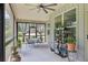 Charming screened-in porch with ceiling fan, dining set, and shelves filled with potted plants at 411 Johnson Rd, Locust Grove, GA 30248