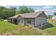 Rear view of house featuring screened patio, well-manicured lawn, and stone accents at 411 Johnson Rd, Locust Grove, GA 30248