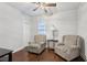 Cozy sitting room with two patterned armchairs, a side table, and a view of the backyard at 411 Johnson Rd, Locust Grove, GA 30248