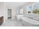 A luxurious bathroom with a freestanding tub, marble surround shower, and a view to walk-in closet at 6080 Simone St, Acworth, GA 30101