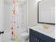 This bathroom has a tub and shower with navy blue vanity and gold fixtures at 6080 Simone St, Acworth, GA 30101
