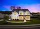 Stunning two-story white home beautifully illuminated at twilight, featuring a landscaped yard and inviting entrance at 6080 Simone St, Acworth, GA 30101