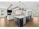 Open kitchen with black island, stainless appliances, pendant lights and seamless flow into the living area at 6080 Simone St, Acworth, GA 30101