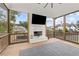 This screened porch is equipped with fireplace, TV, and wood-beamed ceiling at 6080 Simone St, Acworth, GA 30101