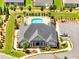 Aerial view of a clubhouse and community pool featuring lush landscaping and ample parking at 1802 Lexington Green Pnes, Cumming, GA 30040