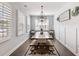 Bright dining room is furnished with modern lighting, a wooden table, and shuttered windows for natural light at 1802 Lexington Green Pnes, Cumming, GA 30040