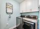 Laundry area featuring modern appliances, overhead storage cabinets, and a fresh, clean aesthetic at 1802 Lexington Green Pnes, Cumming, GA 30040