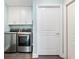 Efficient laundry room includes a modern washer and dryer set, and white cabinets for organized storage at 1802 Lexington Green Pnes, Cumming, GA 30040